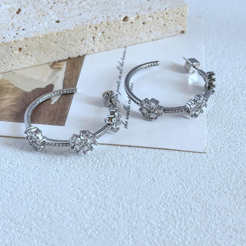 This is a pair of commuting design earrings with a sweet and super sparkling floral inlay style
