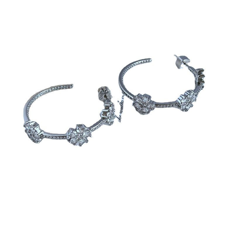 This is a pair of commuting design earrings with a sweet and super sparkling floral inlay style