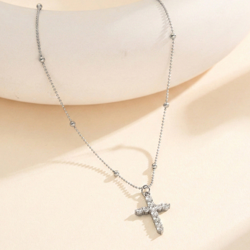 The cross-shaped pendant is set with a high-end and versatile look in yellow